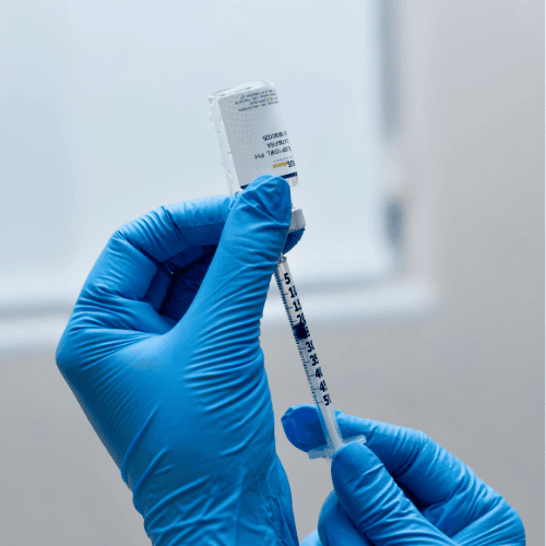 Blue gloves and syringe for aesthetic treatment