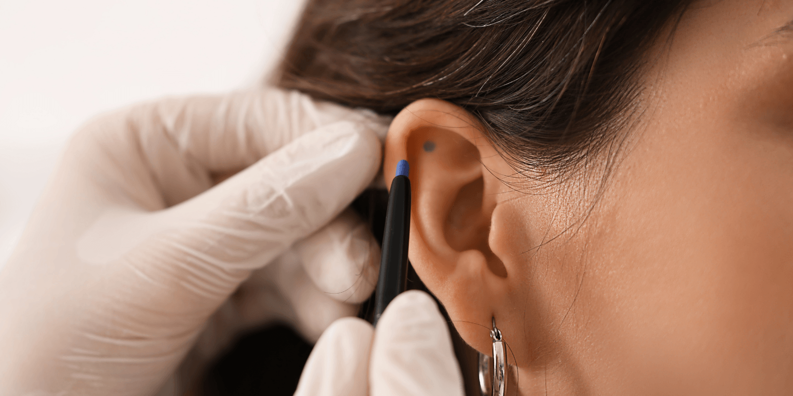 h (23) (1) Close up image of woman getting her ear pierced