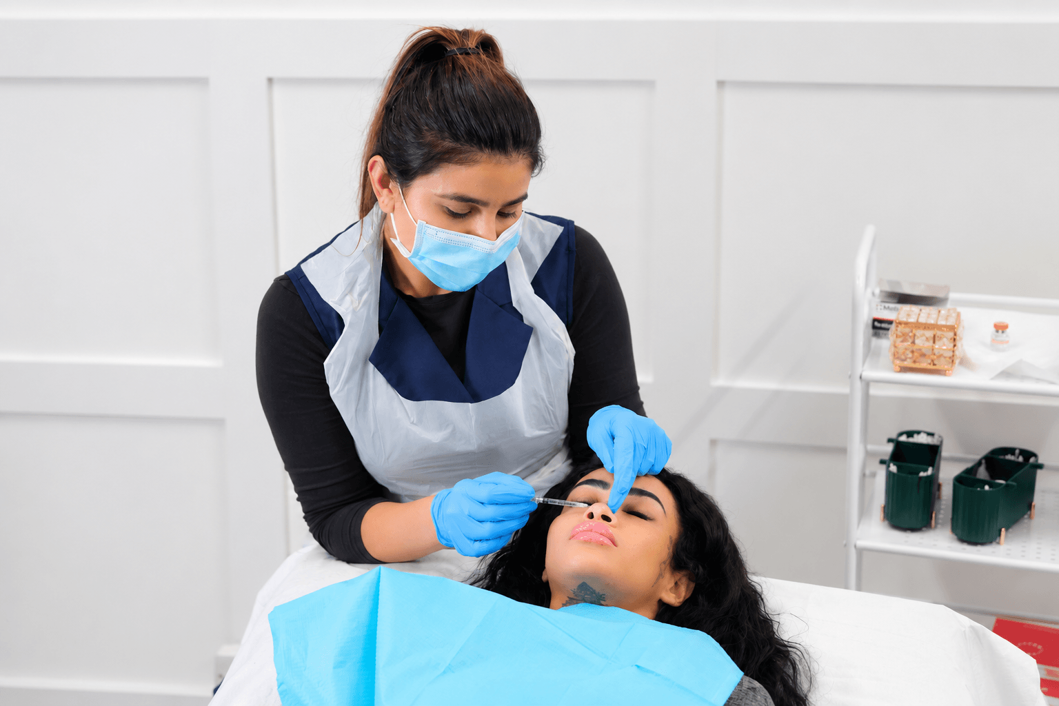 non-surgical-rhinoplasty-treatment Practitioner performing non-surgical rhinoplasty treatment, injecting filler into the nose