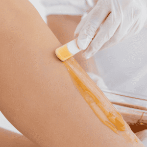 Practitioner applying wax during a leg waxing treatment
