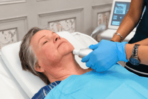 Practitioner performing an RF skin tightening treatment on a client's neck